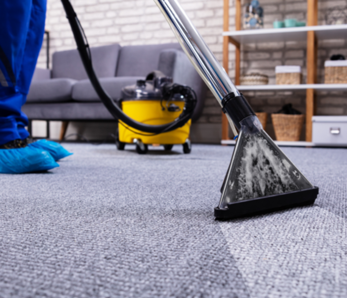 Male cleaning carpets in office space 