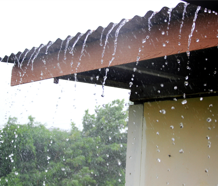 Heavy rain trickling off side of building